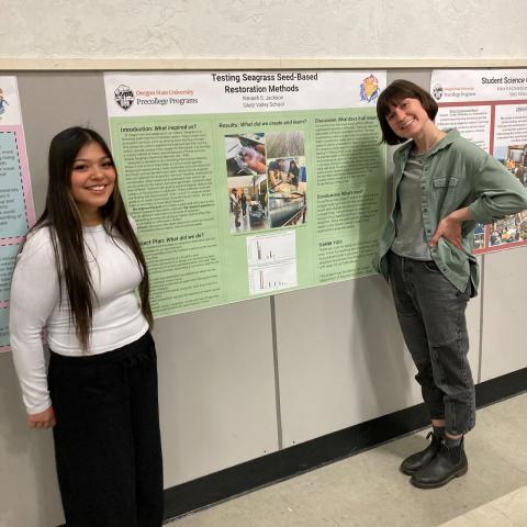 Student and mentor standing by research poster